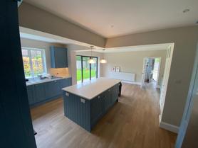 Refurbished open-plan kitchen with island and bifold doors